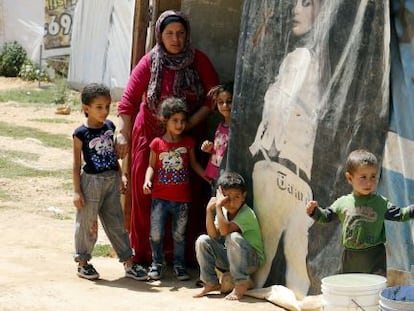 Una mujer y varios niños sirios del campo de refugiados libanés de Saadnayel.