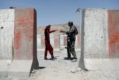 Un soldado del Ejército Nacional Afgano (ANA) inspecciona a un pasajero en un puesto de control en la carretera Ghazni - Kabul en Afganistán.