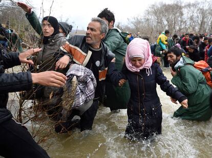 Refugiados y migrantes intentan cruzar un río en su camino a Macedonia desde un campamento improvisado en la frontera griego-macedonia, cerca del pueblo griego de Idomeni, el 14 de marzo de 2016.
