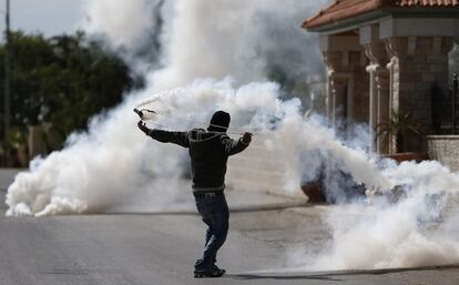 Un manifestante palestino utiliza una honda devolver una granada de gas lacrimógeno a los soldados israelíes durante los enfrentamientos en la aldea cisjordana de Silwad, al norte de Ramallah.