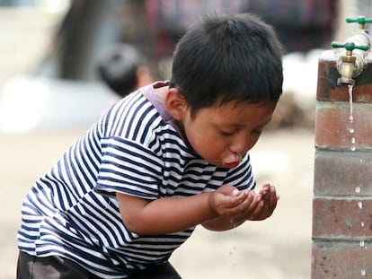 Niño bebe de una fuente de agua en Sololá, Guatemala.