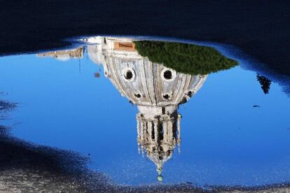 Reflejo sobre un charco de la cúpula de la iglesia de Santa María de Loreto de Roma (Italia).