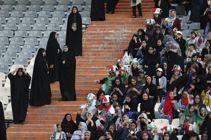 Mujeres iraníes ven el partido de fútbol clasificatorio para la Copa Mundial 2022 entre Irán y Camboya en el estadio Azadi en Teherán (Irán), custodiadas por 150 mujeres policía.