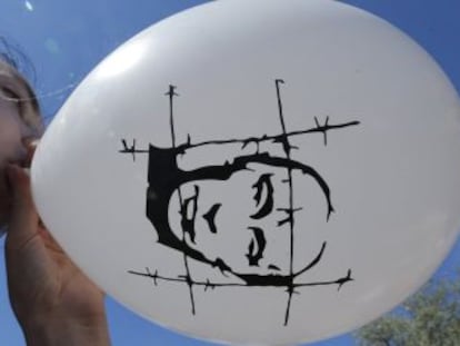 Una manifestante anti-Putin infla un globo con la cara del presidente, en una protesta en Mosc&uacute;. 