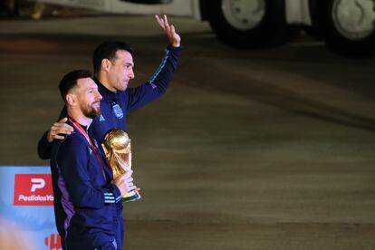 Lionel Messi de la selección argentina de fútbol saluda con el trofeo del Mundial de Fútbol Qatar 2022 junto al seleccionador Lionel Scaloni (d) a su llegada hoy, al Aeropuerto Internacional de Ezeiza a unos 22km de Buenos Aires (Argentina).