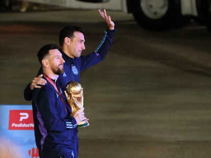 Lionel Messi de la selección argentina de fútbol saluda con el trofeo del Mundial de Fútbol Qatar 2022 junto al seleccionador Lionel Scaloni (d) a su llegada hoy, al Aeropuerto Internacional de Ezeiza a unos 22km de Buenos Aires (Argentina).