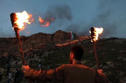 Un kurdo iraquí sostiene antorchas en la ciudad de Akra, durante las celebraciones de Nowruz (Noruz).