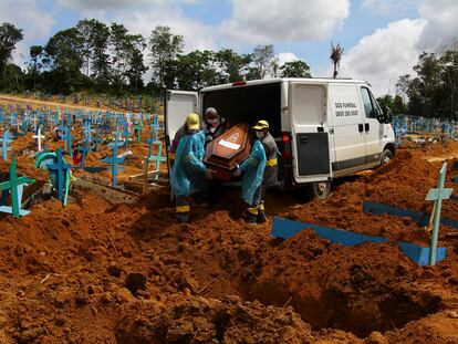 Trabajadores de un cementerio llevan los restos de un hombre que murió a causa del coronavirus, para enterrarlos en el cementerio Nossa Senhora Aparecida en Manaus, estado de Amazonas, Brasil, el pasado 6 de enero.