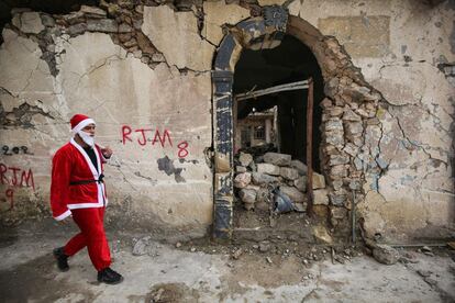 La guerra y los conflictos sectarios han reducido la población cristiana del país desde los 1,5 millones hasta los cerca de 400.000 tras la invasión encabezada por Estados Unidos en 2003. En la foto, un joven vestido de Santa Claus, camina por las calles de Mosul.