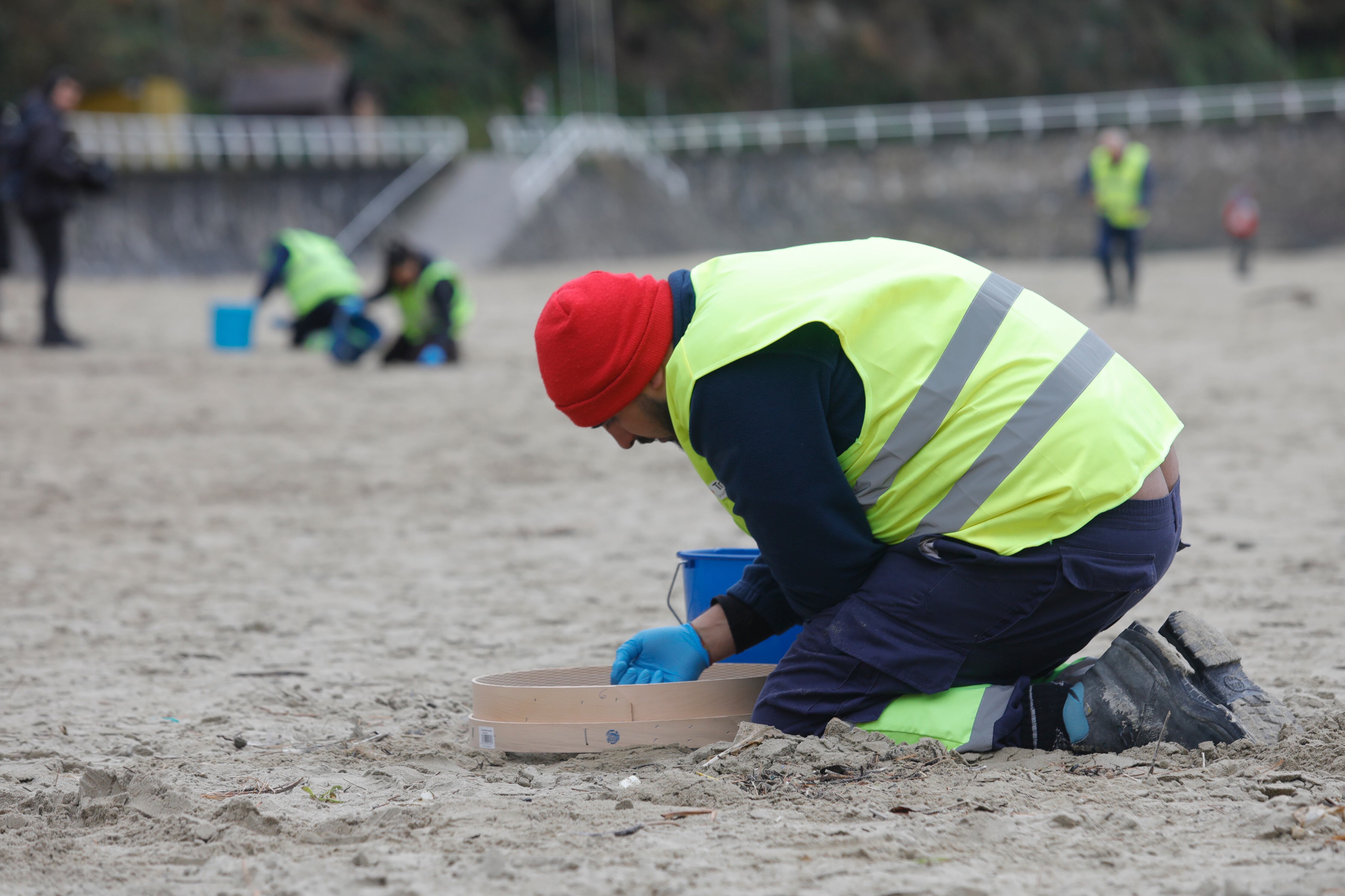 Un operario recoge 'pellets' de plástico en la playa asturiana de Aguilar, en Muros de Nalón, este martes. 