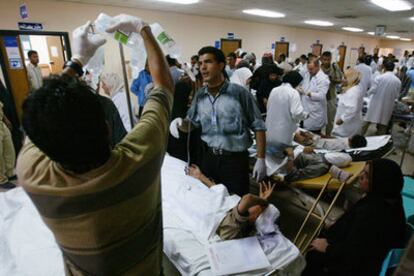 Equipos médicos socorren a los heridos en los pasillos de un hospital, tras la explosión, ayer en Bagdad, de un coche bomba en el barrio de Kadimiya.