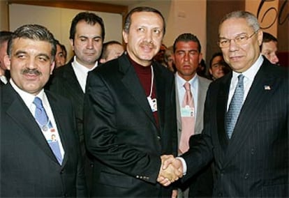 Colin Powell (derecha) estrecha la mano de Recep Tayyip Erdogan, líder del Partido Islamista turco, ayer en Davos.