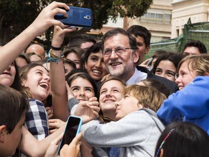 Mariano Rajoy se hace una foto rodeado de niños en una visita a Alicante.