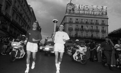 La antorcha a su paso por la Puerta del Sol. Al fondo el anuncio Tío Pepe, en su ubicación de 1992 en el hotel París y que ahora es la tienda de Apple. En la actualidad, el cartel publicitario se encuentra en el número 11 de la plaza.