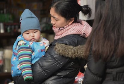 Una madre con su bebé en una calle de Shanghái.