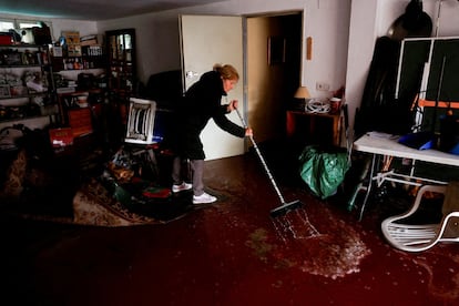 María Luisa limpia la planta baja de su vivienda inundada tras las fuertes lluvias en Ávila.