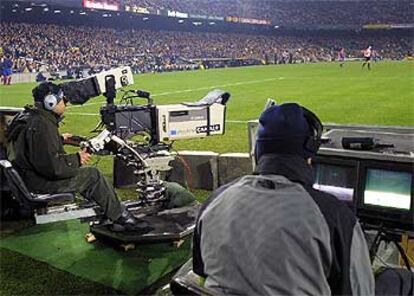 Cámaras de televisión en el Camp Nou durante un partido de Liga.