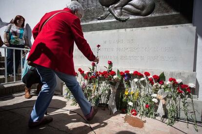 Una persona coloca una flor delante del monumento a la República.