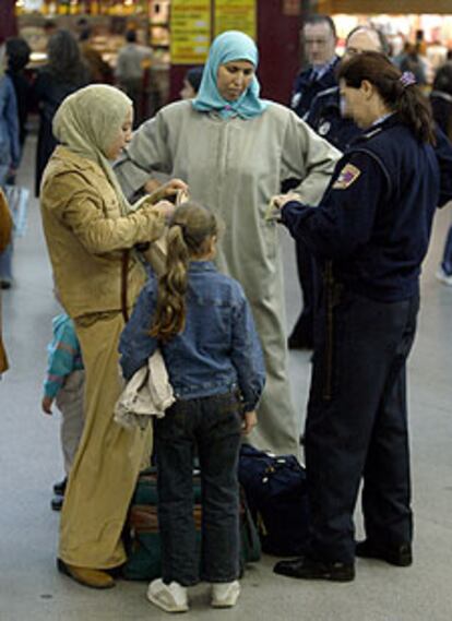 Una polica identifica a dos mujeres marroques, ayer, en el intercambiador de Moncloa de Madrid.