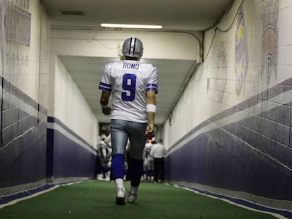 Romo camina en uno de los túneles del estadio de Texas