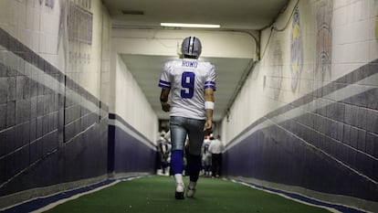 Romo camina en uno de los túneles del estadio de Texas