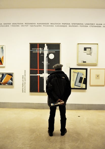 Un visitante del Museo Thyssen-Bornemisza en la sala de las vanguardias rusas. En el centro, <i>Composición suprematista</i> (1923), de Ilyá Chashnik. A la derecha, tres obras de El Lissitzky. Y a la izquierda, asomándose, dos cuadros de Liubov Popova.