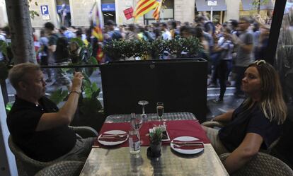 Dos mujeres miran desde un restaurante la manifestación de estudiantes convocada en Barcelona.