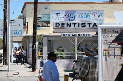 Dos turistas caminan junto a una clínca dental en Algodones, el pasado 11 de abril.