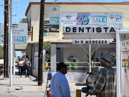 Dos turistas caminan junto a una clínca dental en Algodones, el pasado 11 de abril.