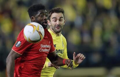 El delantero del Villarreal, Adrián López (d), lucha el balón con Jordon Ibe, del Liverpool.