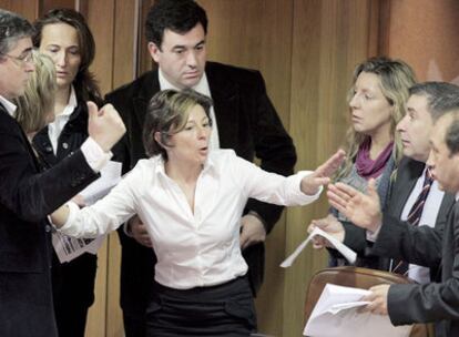 La socialista Mar Barcón, en el centro, discute con otros diputados una enmienda de última hora presentada por el PP.