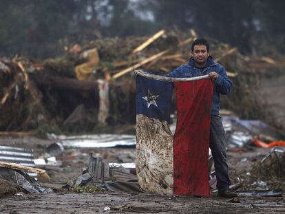 Bruno Sandoval, un artesano, muestra a la cámara la bandera chilena tras el terremoto de febrero pasado.