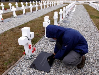 Un hombre junto a una de las tumbas del cementerio de Darwin en las islas Malvinas.