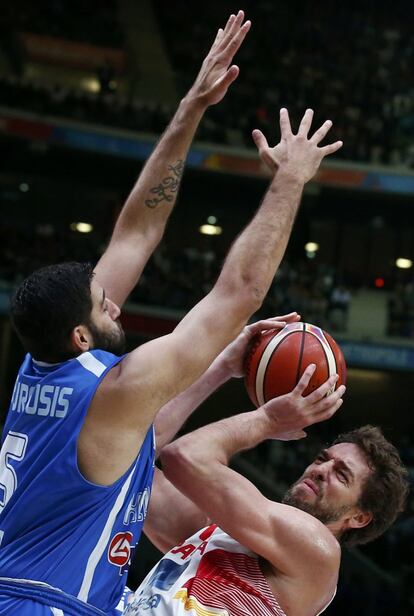 El pívot español Pau Gasol (i) intenta tirar a canasta antes la defensa de un Yannis Bourousis con los brazos extendidos.