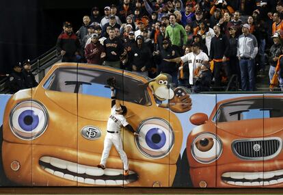 El jugador venezolano de los Gigantes de San Francisco, Gregor Blanco, no puede alcanzar la bola bateada por Kris Bryant, de los Cachorros de Chicago, durante la 9º entrada del tercer partido de la fase final de la Liga Nacional de béisbol profesional en el estadio AT&T Park de San Francisco, California (Estados Unidos) el 10 de octubre.