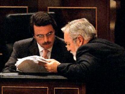 Aznar consulta unos documentos con el ministro de Agricultura, Miguel Arias Cañete, ayer en el Congreso.