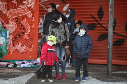 Una familia, todos con mascarilla de protección, permanece cerca a una estación de metro este lunes, en Sao Paulo (Brasil).