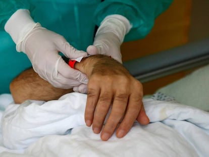 Una enfermera sostiene la mano de un enfermo de la covid-19 en un hospital en Berlín