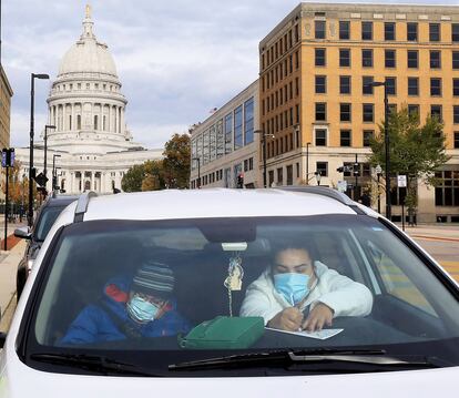 Dos residentes de Madison, Wisconsin, llenan sus papeletas de voto anticipado ante el capitolio de la ciudad.