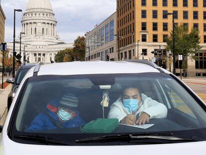 Dos residentes de Madison, Wisconsin, llenan sus papeletas de voto anticipado ante el capitolio de la ciudad.