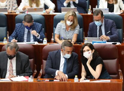 Enrique López e Isabel Díaz Ayuso hablan durante un pleno de la Asamblea de Madrid. 