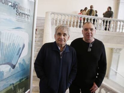 El escritor Bernardo Atxaga y el director Fernando Bernués ante el cartel del filme 'El hijo del acordeonista'.
