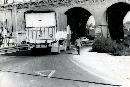 Un peatón caminaba junto al tráfico que circulaba bajo el arco central del puente de los Tres Ojos, en Vallecas, antes de su demolición a 1983. Su construcción se inició en 1847 y terminó en 1850 para que la línea férrea Madrid-Aranjuez, salvara el arroyo del Abroñigal. Tras la construcción de la M-30 se convirtió en un cuello de botella que provocaba enormes atascos. Allí ocurrieron varios accidentes mortales.