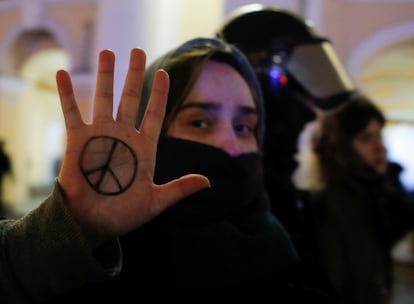 Una manifestante detenida en San Petersburgo muestra el símbolo de la paz pintado en su mano.