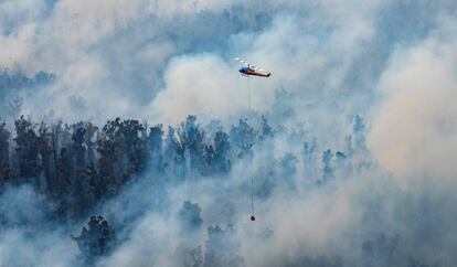 Un helicóptero participa en las labores de extinción de un incendio en la región de Gippsland Este (Australia). Los fuegos han arrasado más de cuatro millones de hectáreas y provocado la muerte de once personas.