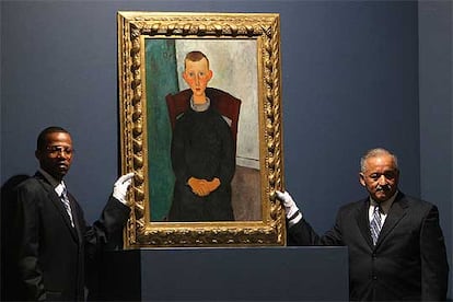 Dos empleados de Sotheby&#39;s muestran <i>El hijo del portero</i><b> (Modigliani).