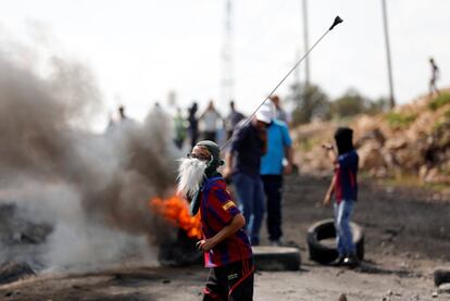 Un chico palestino utiliza una honda para lanzar piedras contra las tropas isralíes durante los enfrentamientos cerca del asentamiento judío de Wadomem, en Cisjordania.