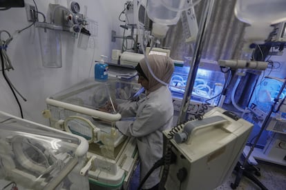 Een vrouw verzorgt een baby in een ziekenhuis in de wijk Rimal in Gaza, maandag.