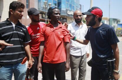 Varios rebeldes interpelan a un hombre en Trípoli.