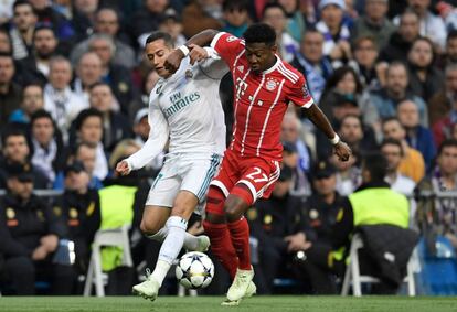 El defensa del Bayern David Alaba (d) pelea por el balón junto al centrocampista Lucas Vazquez del Real Madrid.  